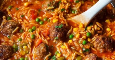 Bunte Orzo-Pfanne mit Hackbällchen serviert auf einem Teller