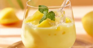 Eierlikörbowle mit Ananas und Sekt in einem eleganten Glas serviert.
