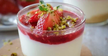 Leckeres Erdbeer-Dessert im Glas mit frischen Erdbeeren und Sahne.