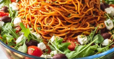 Italienischer Spaghetti-Schichtsalat mit frischen Zutaten und bunten Schichten