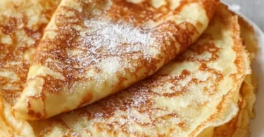 Leckere Pfannkuchen auf einem Teller mit frischen Früchten und Sirup