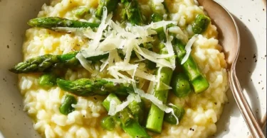 Risotto mit grünem Spargel auf einem Teller serviert