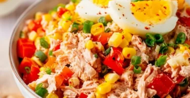 Thunfisch-Salat mit Eiern, Mais und Paprika in einer Schüssel serviert