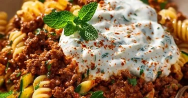Türkische Pasta mit Hackfleisch und Joghurt-Sauce auf einem Teller serviert.